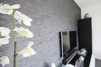 Natursteinwand im Wohnzimmer im Neubau Massivhaus - zwo ARCHITEKTEN HAUS - Designhaus